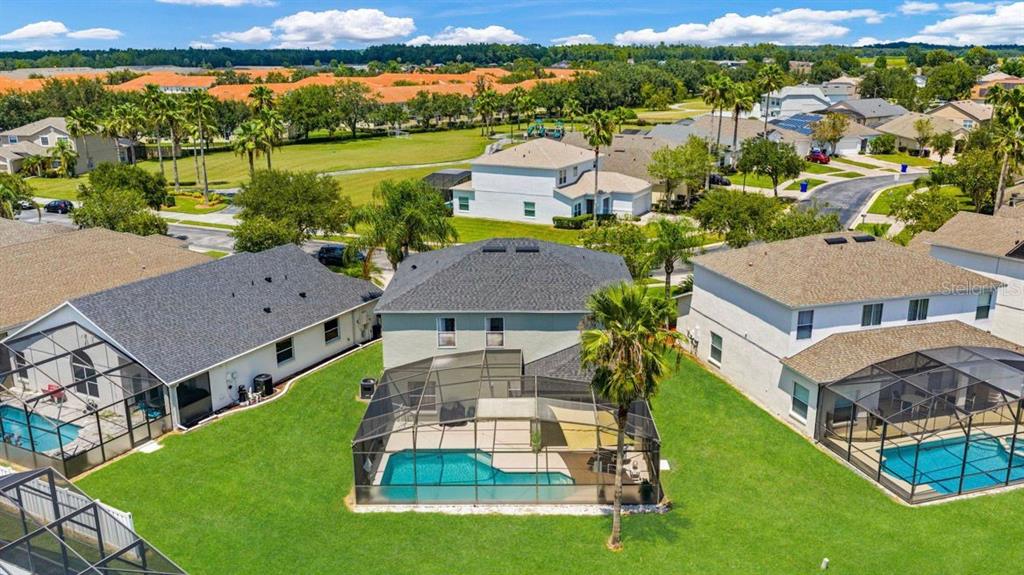 An aerial view of a suburban house with a screened-in pool and backyard — 4817 CUMBRIAN LAKES DRIVE, KISSIMMEE, FL