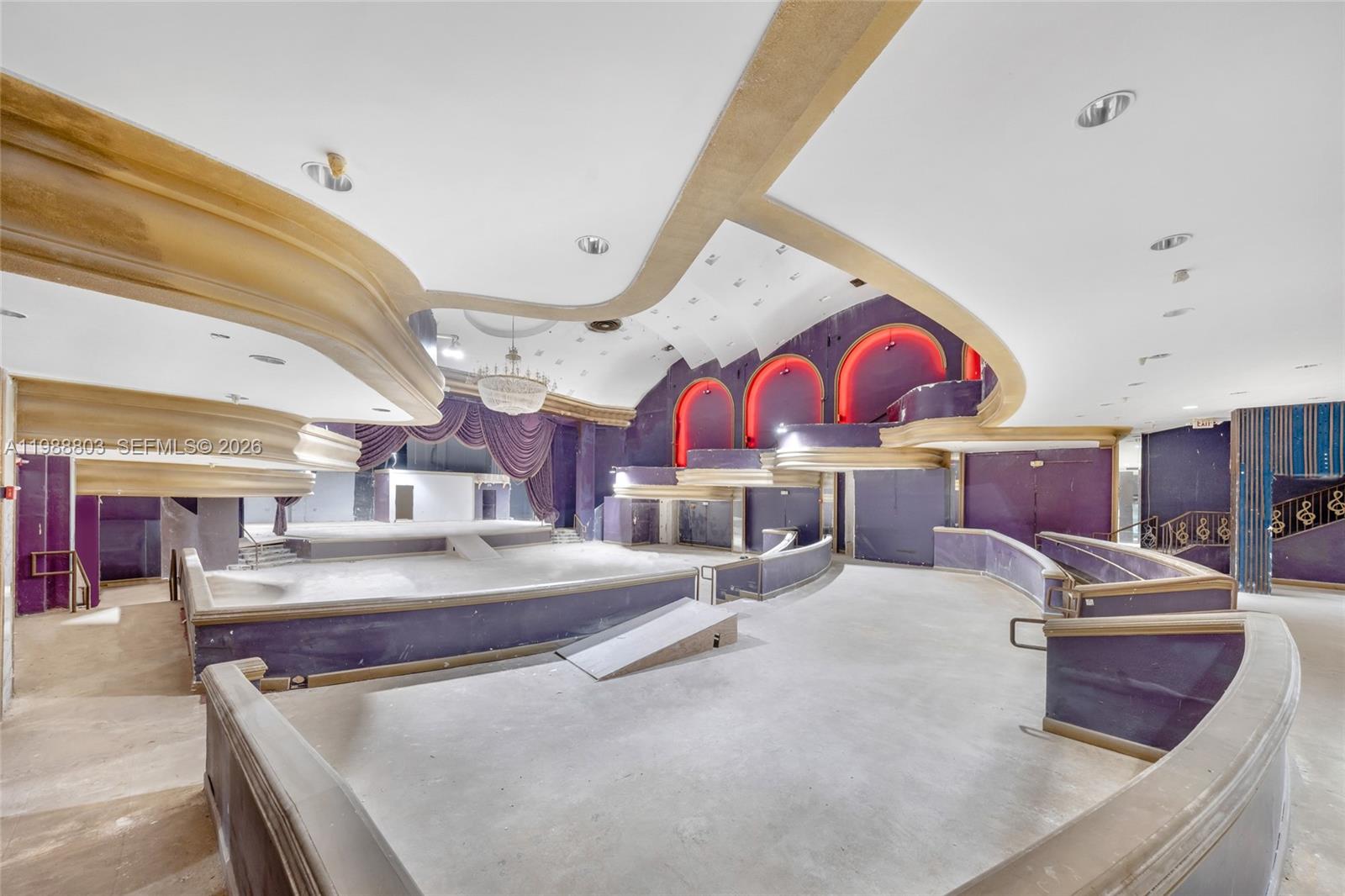 A large, vacant event hall features purple walls, tiered platforms, and a decorative ceiling — 5445 Collins Ave, Miami Beach FL 33140, MIAMI BEACH, FL