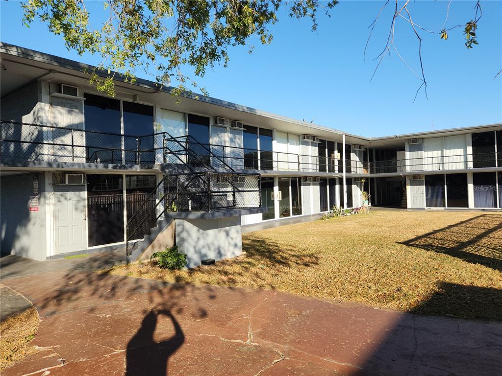 A two-story apartment building with exterior walkways and a central grassy courtyard — 1202 RIDGEWOOD AVENUE, HOLLY HILL, FL