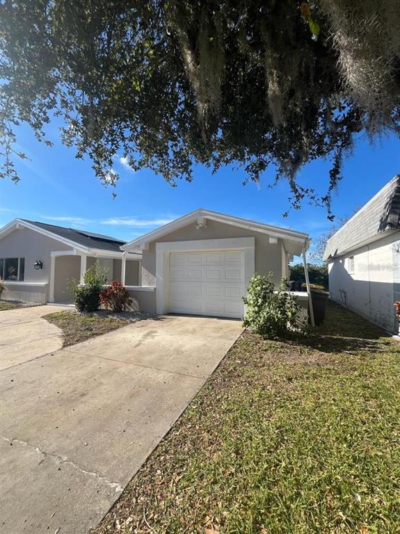 A concrete driveway leads to a one-car garage attached to a single-story residential home — 3631 GRAYTON DRIVE, NEW PORT RICHEY, FL
