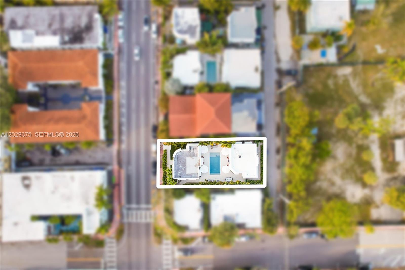 This aerial view shows a residential property with a swimming pool and a white roof — 8109 Harding Ave, Miami Beach FL 33141, MIAMI BEACH, FL