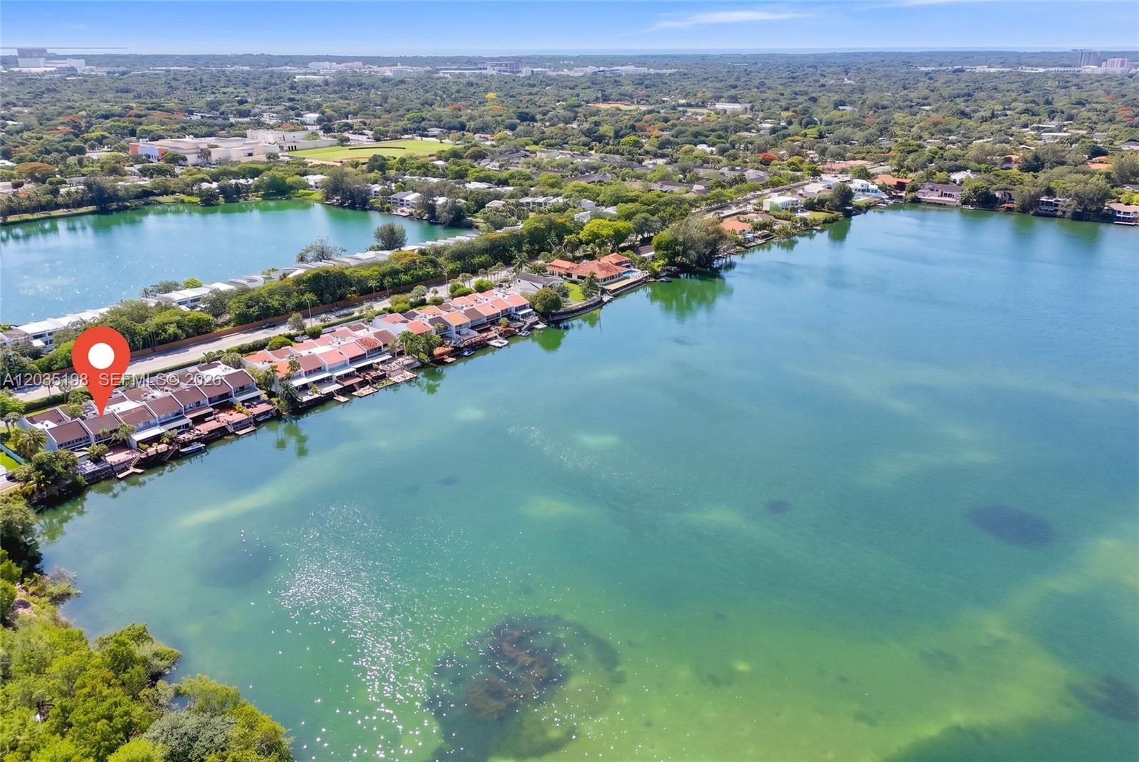 An aerial view shows a row of waterfront townhouses situated along a large lake — 5002 SW 72nd Ave, Miami FL 33155, MIAMI, FL