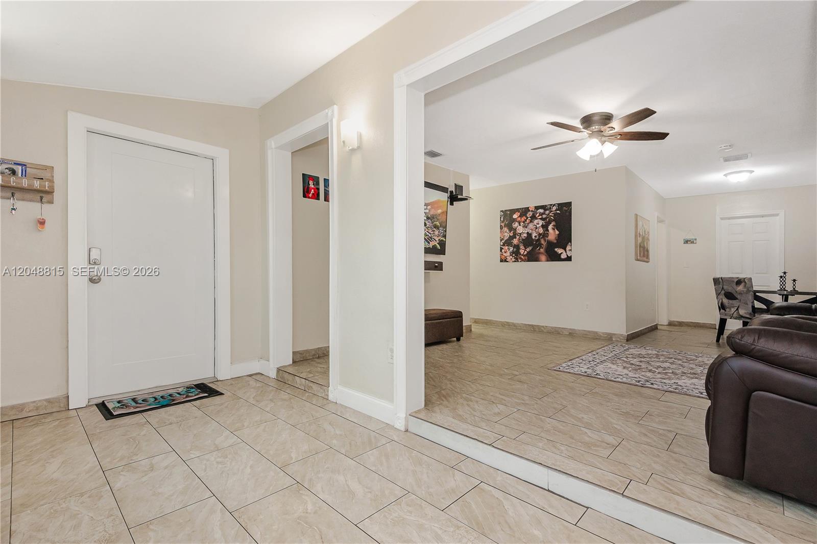A tiled entryway leads into a living area with a sunken floor and ceiling fan — 750 NE 4th Pl, Hialeah FL 33010, HIALEAH, FL