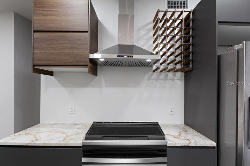A kitchen features a stainless steel range, a range hood, and a wine rack — 3417 SE TENNESSEE TERRACE, ORLANDO, FL