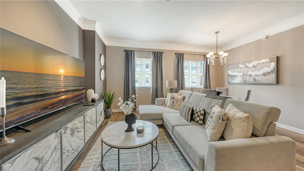 A living room features a large television, a sectional sofa, and a marble-topped coffee table — 1064 N TAMIAMI TRAIL UNIT 1522, SARASOTA, FL