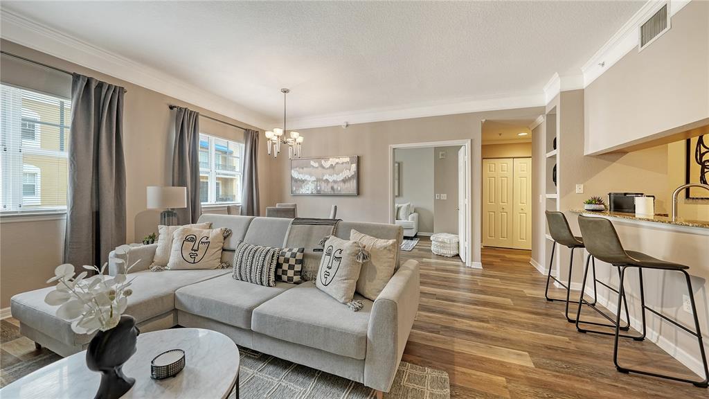 A living room with a sectional sofa, dining area, and kitchen counter with bar stools — 1064 N TAMIAMI TRAIL UNIT 1522, SARASOTA, FL