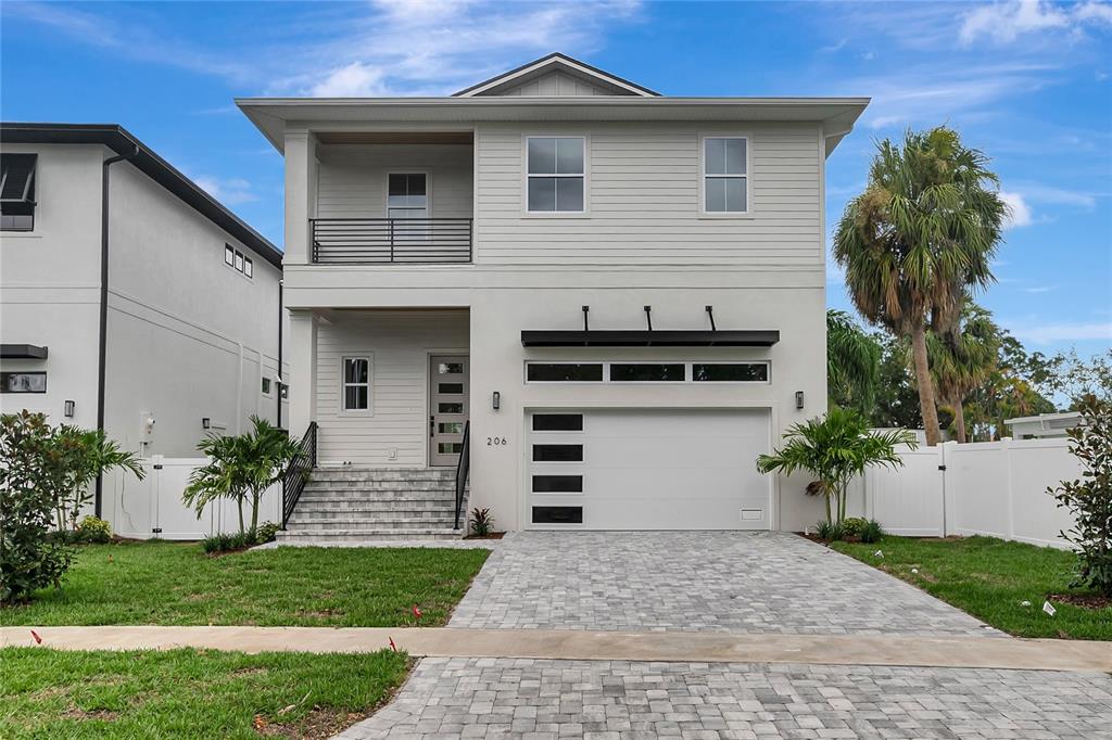 A two-story house with a light-colored exterior, a balcony, and a paved driveway — 206 CHIPPEWA AVENUE, TAMPA, FL
