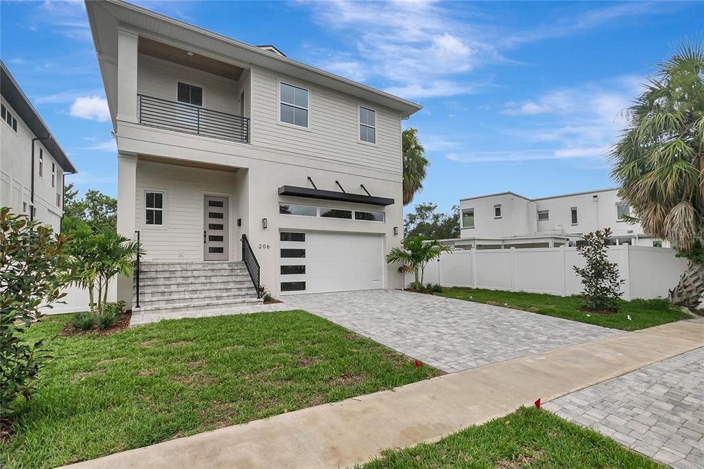 A two-story house with a white exterior, a front balcony, and a paved driveway — 206 CHIPPEWA AVENUE, TAMPA, FL