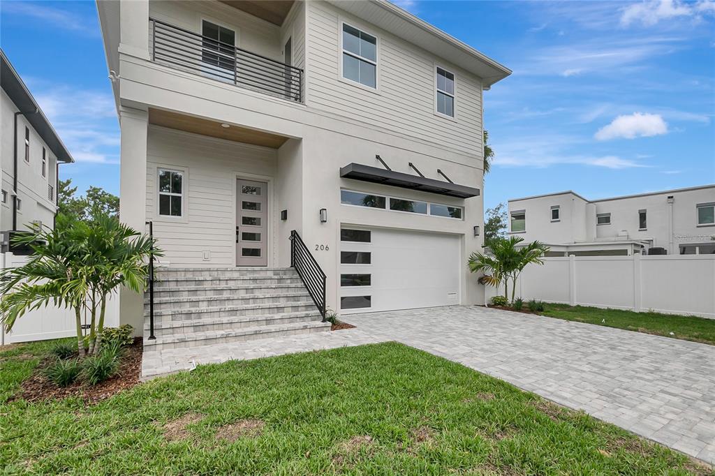 A two-story house with a white exterior, a paved driveway, and a front staircase — 206 CHIPPEWA AVENUE, TAMPA, FL