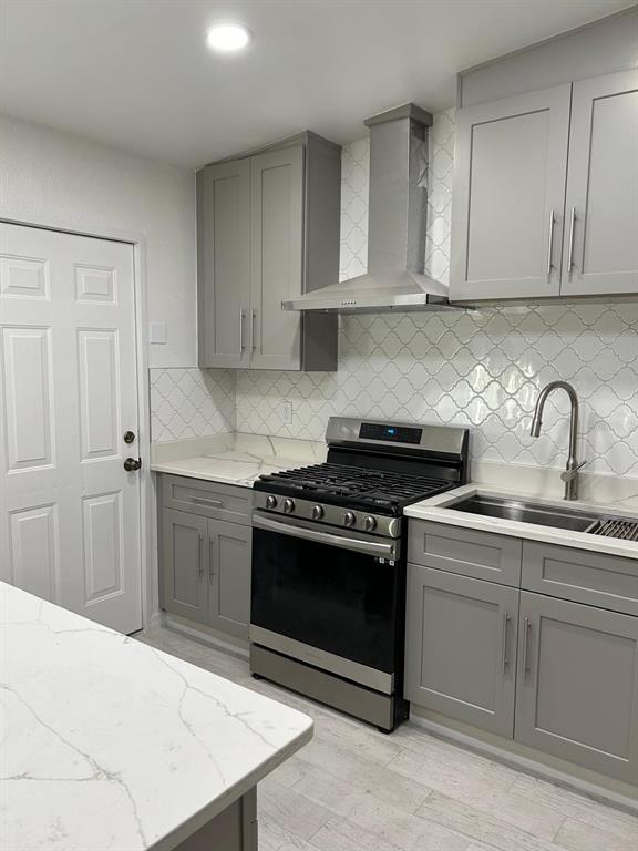 A kitchen features gray cabinets, white marble-look countertops, a stainless steel stove, and patterned backsplash — 1838 COLTON DRIVE, ORLANDO, FL