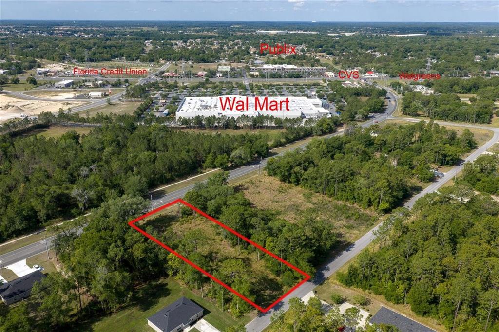 An aerial view shows a vacant, rectangular plot of land outlined in red near commercial businesses — BAHIA TERRACE DRIVE, OCALA, FL