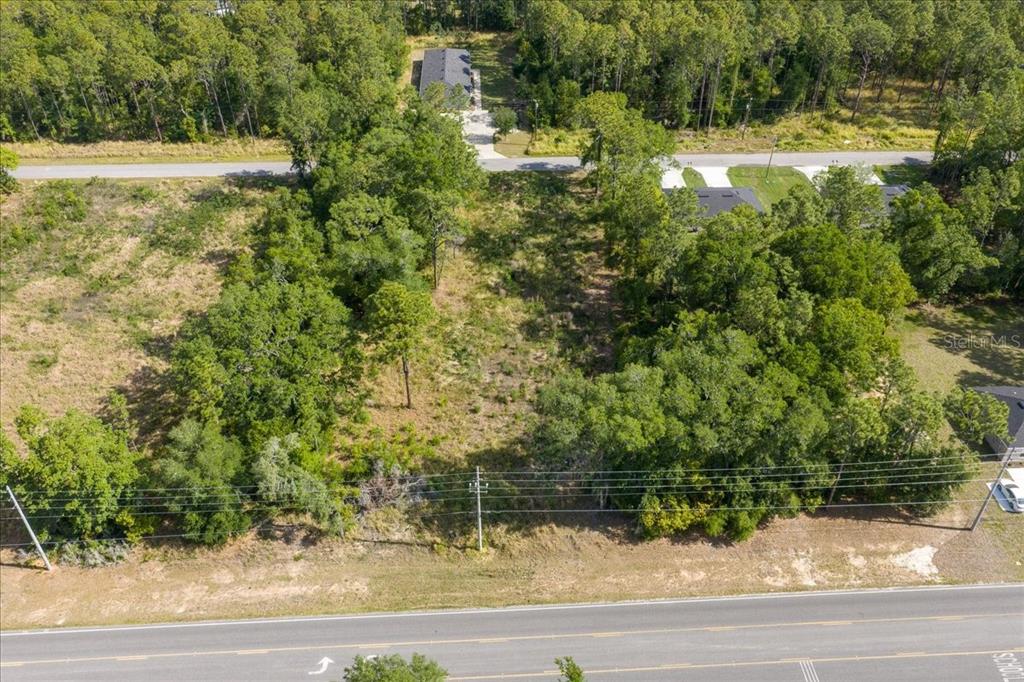 An aerial view shows a wooded, undeveloped rectangular lot situated between two paved roads — BAHIA TERRACE DRIVE, OCALA, FL
