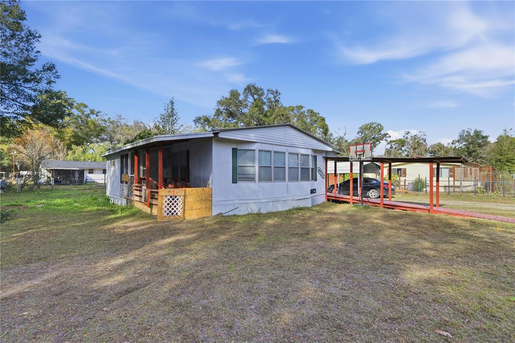A single-story mobile home with a covered porch and a red-framed walkway — 6520 NE 23RD AVENUE, OCALA, FL
