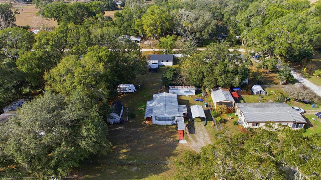 An aerial view shows several mobile homes and outbuildings situated on a wooded lot — 6520 NE 23RD AVENUE, OCALA, FL