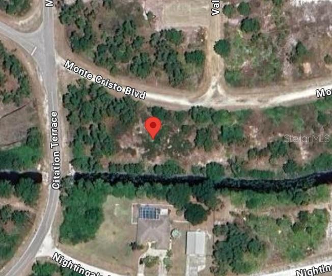 This is an aerial map view showing a vacant lot marked with a red pin — 28033 MONTE CRISTO BOULEVARD, PUNTA GORDA, FL