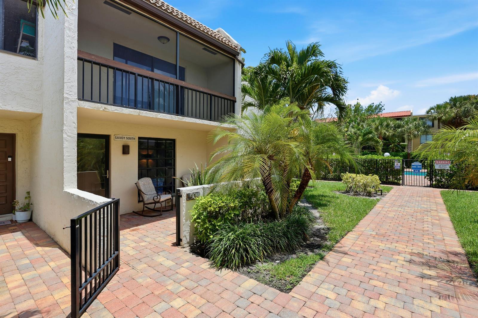 A two-story building with a screened balcony and a brick patio sits beside a pool — 721 SE 1st Way # C11, Deerfield Beach FL 33441, DEERFIELD BEACH, FL
