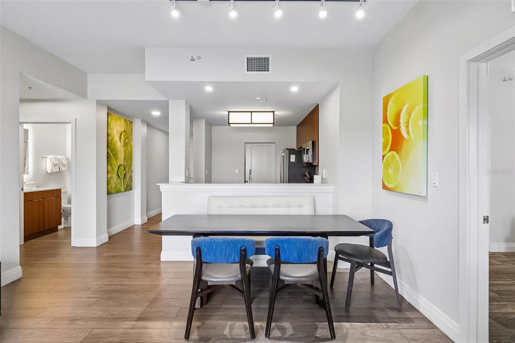 A dining area with a dark table, blue chairs, and a white bench against a wall — 14501 GROVE RESORT AVENUE UNIT 2342, WINTER GARDEN, FL