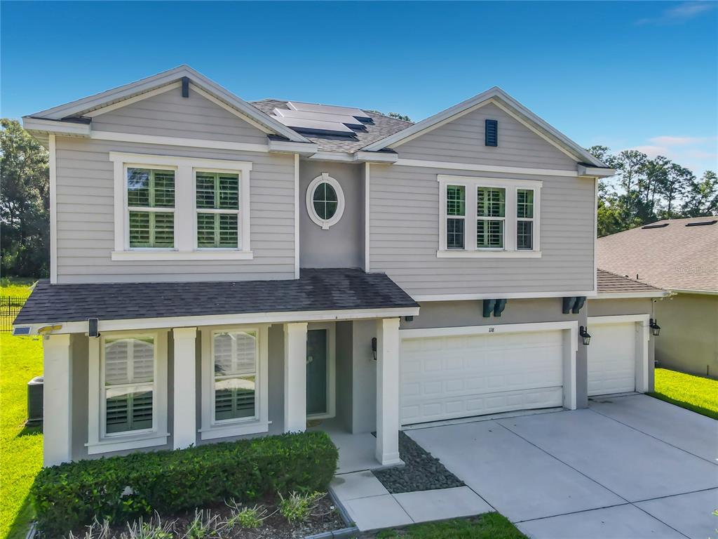 A two-story house with gray siding, a white garage, and a front porch — 118 VICTORIA OAKS BOULEVARD, DELAND, FL