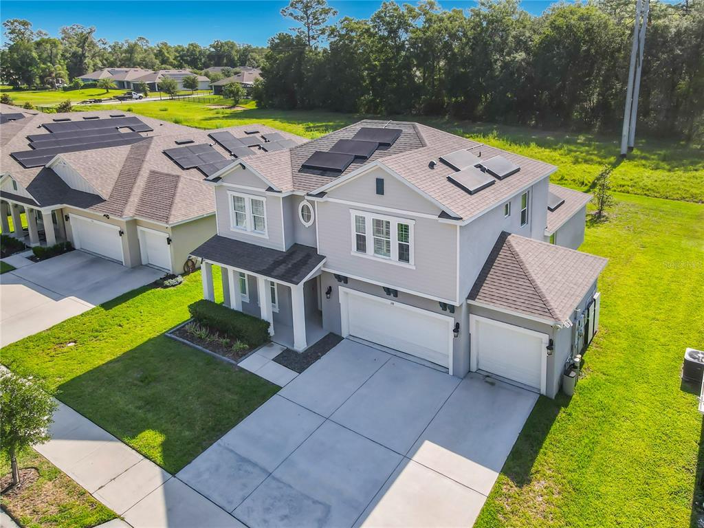 An aerial view of a two-story suburban house with solar panels and a three-car garage — 118 VICTORIA OAKS BOULEVARD, DELAND, FL