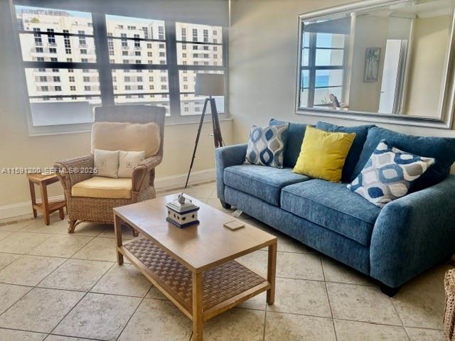 A living room features a blue sofa, a wicker armchair, and a wooden coffee table — 100 Lincoln Rd # 1434, Miami Beach FL 33139, MIAMI BEACH, FL