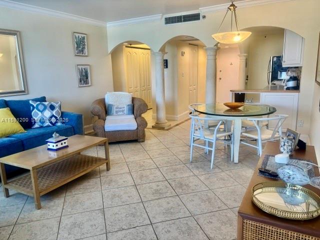 A living room with a blue sofa, wicker armchair, dining table, and tiled flooring — 100 Lincoln Rd # 1434, Miami Beach FL 33139, MIAMI BEACH, FL