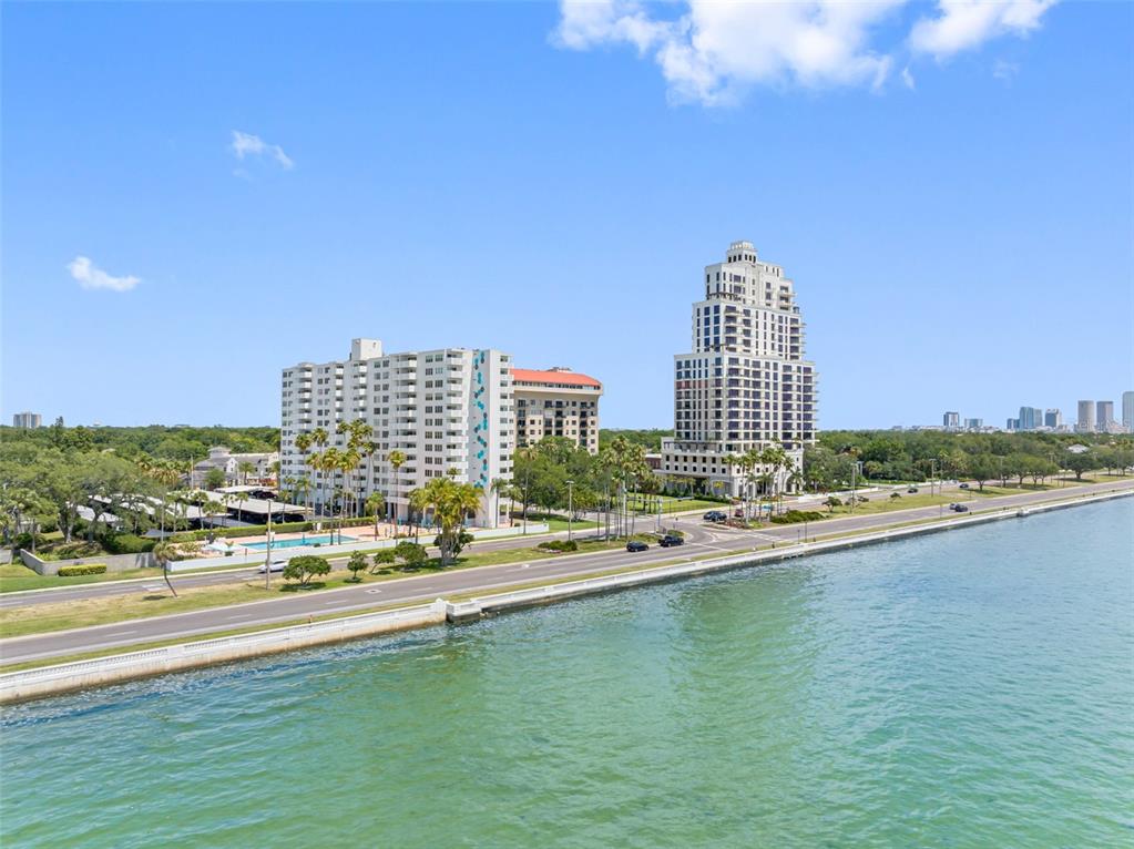 An aerial view shows two large apartment buildings situated along a coastal road — 2401 BAYSHORE BLVD UNIT 502, TAMPA, FL