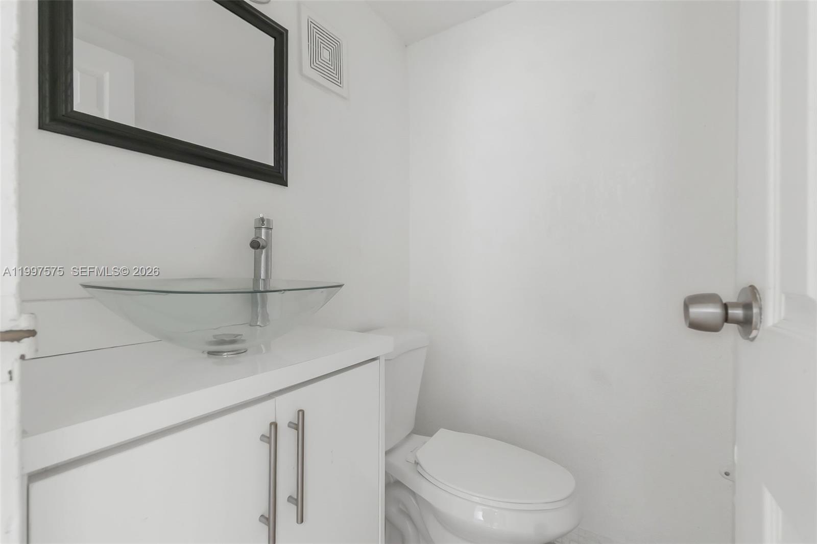 A small bathroom features a white vanity with a glass vessel sink and a toilet — 1798 NW 55th Ave # 202, Lauderhill FL 33313, LAUDERHILL, FL