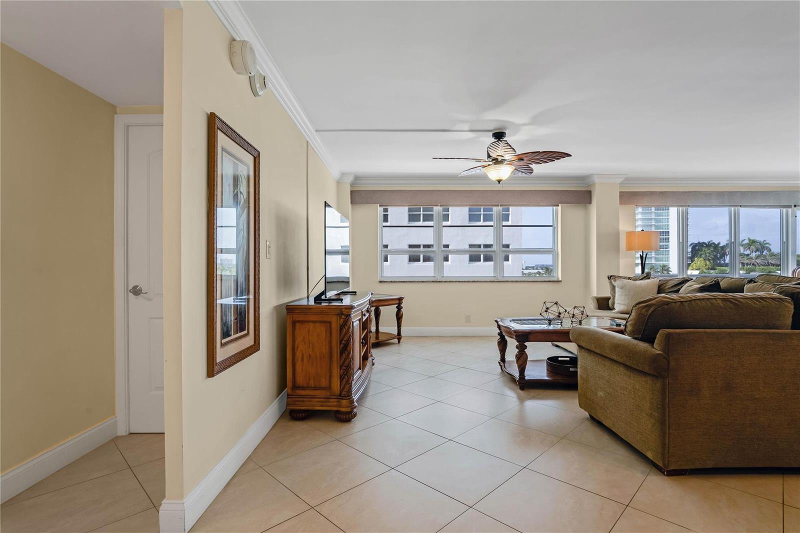 A living room features tile flooring, a ceiling fan, a television console, and a sofa — 133 N Pompano Beach Boulevard # 501, Pompano Beach FL 33062, POMPANO BEACH, FL