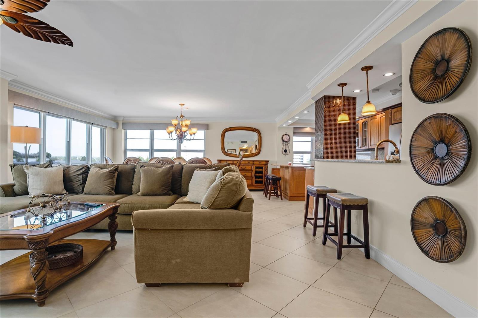 A living room with a sectional sofa, tile flooring, and a kitchen breakfast bar — 133 N Pompano Beach Boulevard # 501, Pompano Beach FL 33062, POMPANO BEACH, FL