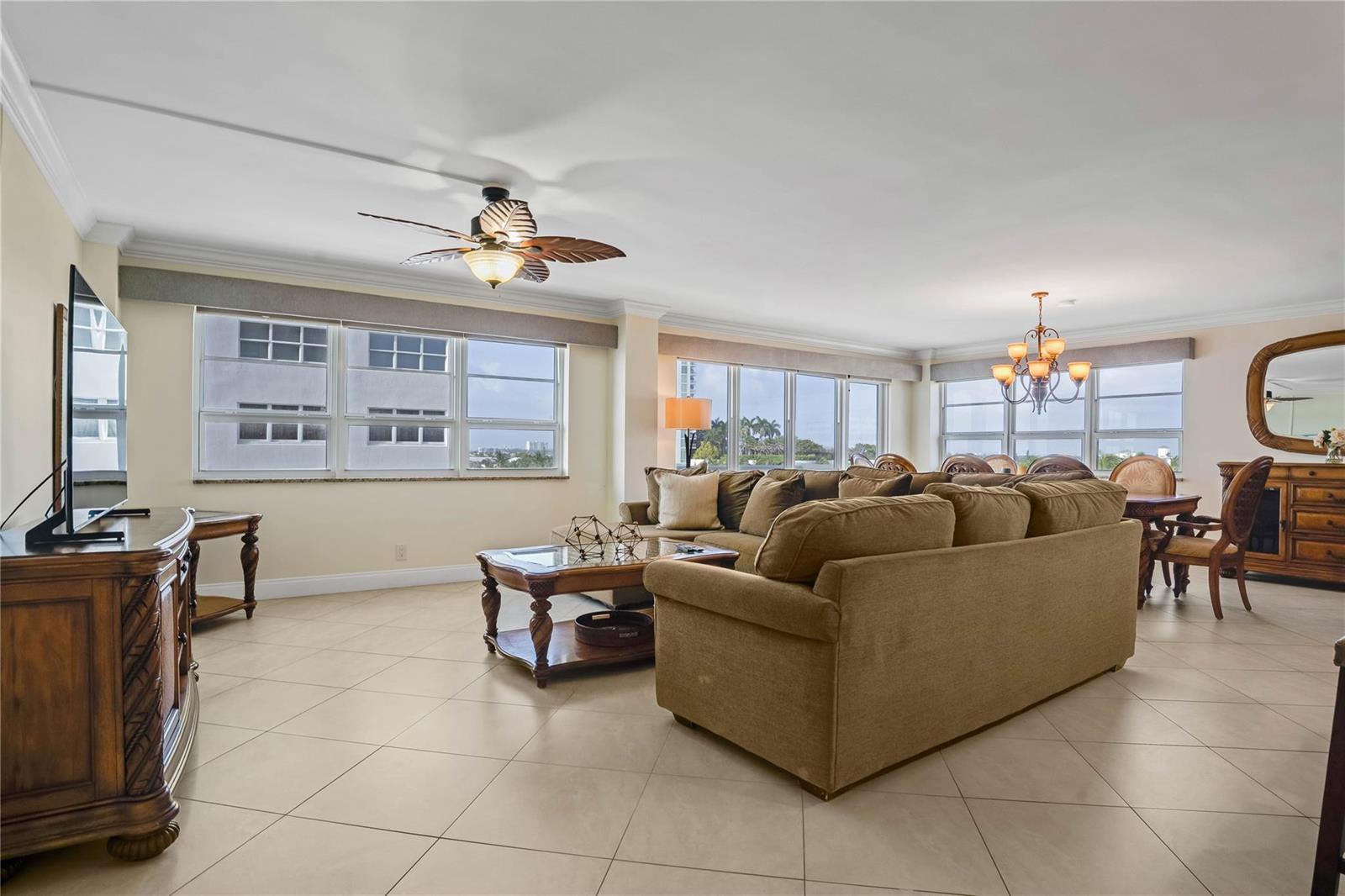 A living and dining area with tile floors, a large sectional sofa, and expansive windows — 133 N Pompano Beach Boulevard # 501, Pompano Beach FL 33062, POMPANO BEACH, FL