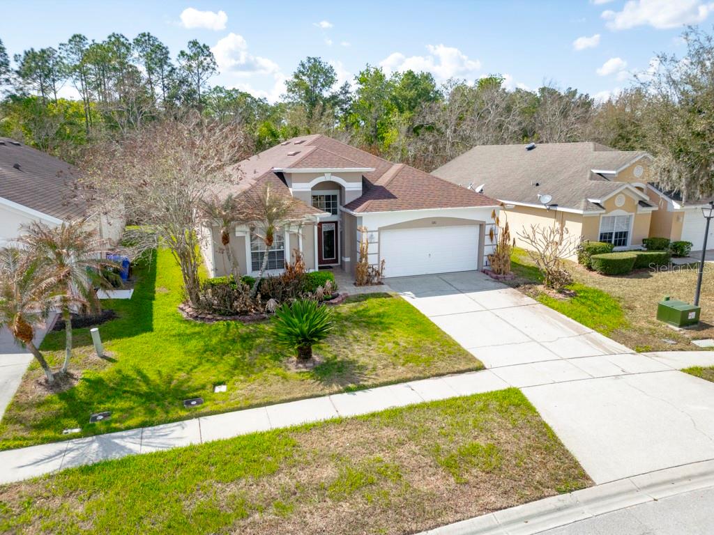A single-story suburban house with a brown shingled roof, white garage, and landscaped front yard — 3181 STONEHURST CIRCLE, KISSIMMEE, FL