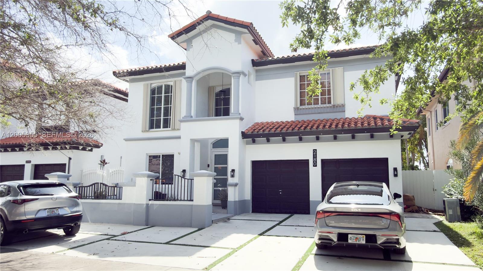 A two-story white house with a tile roof, two garage doors, and two parked cars — 2180 SW 152nd Pl, Miami FL 33185, MIAMI, FL