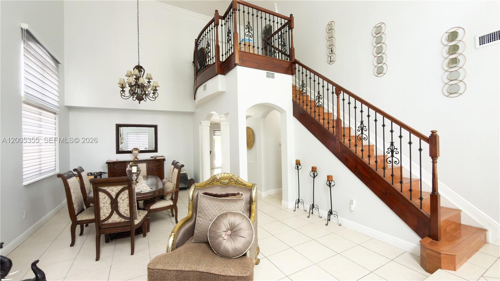 A dining area and staircase with dark wood railings are visible in this open room — 2180 SW 152nd Pl, Miami FL 33185, MIAMI, FL