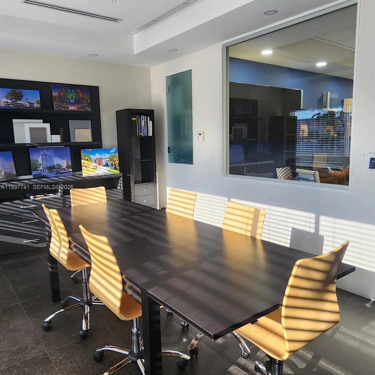 A conference room features a dark table, light-colored chairs, and a large interior window — 2441 NW 93 # B, Doral FL 33172, DORAL, FL