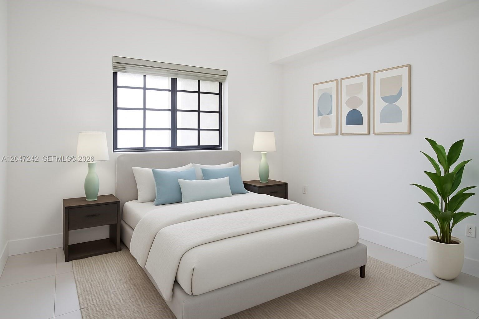 This bedroom features a bed with blue pillows, two nightstands with lamps, and wall art — 1901 S Le Jeune Rd # 2, Coral Gables FL 33134, CORAL GABLES, FL