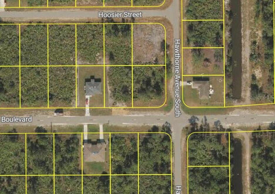 This aerial map shows residential lots and houses at the intersection of two streets — 885 MILWAUKEE BOULEVARD, LEHIGH ACRES, FL
