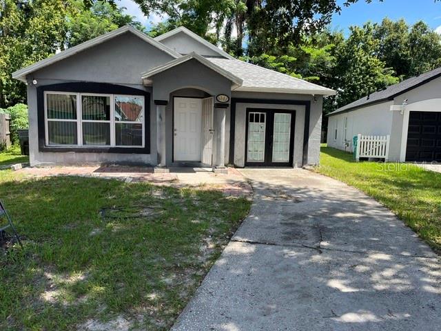 A gray single-story house with a concrete driveway and a white picket fence — 4001 KALUGA PARK STREET, ORLANDO, FL