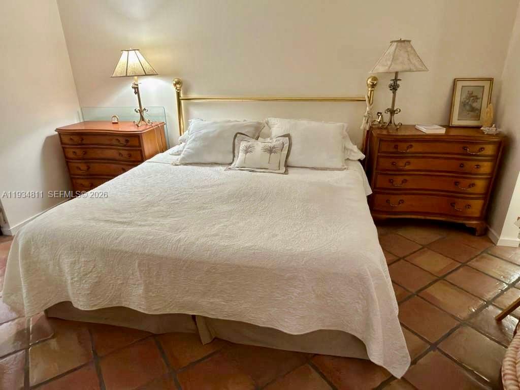 A bedroom features a bed with a brass headboard between two wooden dressers and lamps — 55 Ocean Lane Dr # 1030, Key Biscayne FL 33149, KEY BISCAYNE, FL