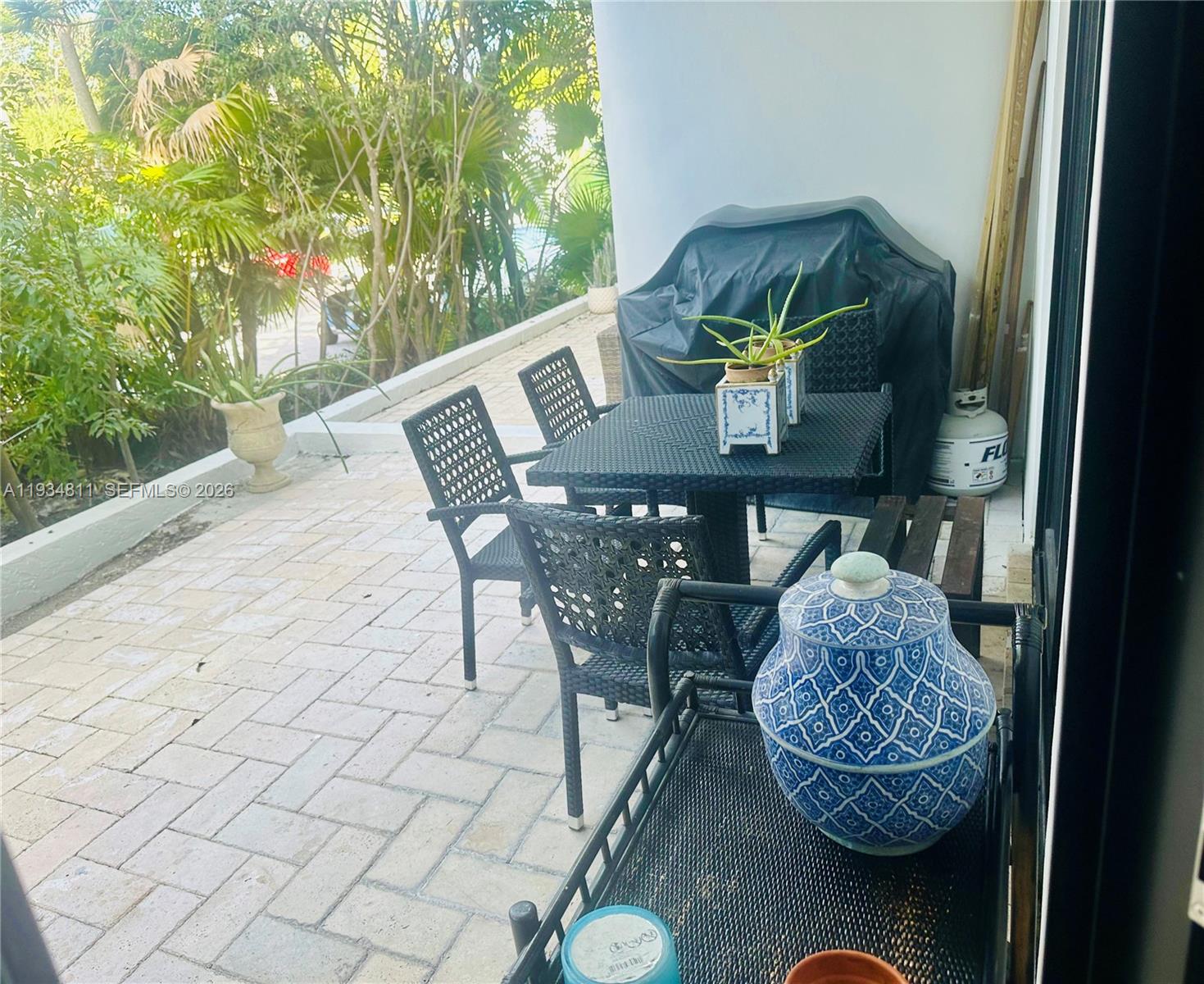 A patio features a small dining set, a covered grill, and a decorative ceramic jar — 55 Ocean Lane Dr # 1030, Key Biscayne FL 33149, KEY BISCAYNE, FL