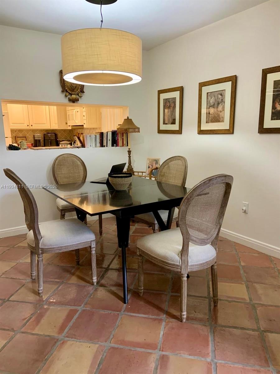 A dining area features a square table, four cane-back chairs, and terracotta tile flooring — 55 Ocean Lane Dr # 1030, Key Biscayne FL 33149, KEY BISCAYNE, FL