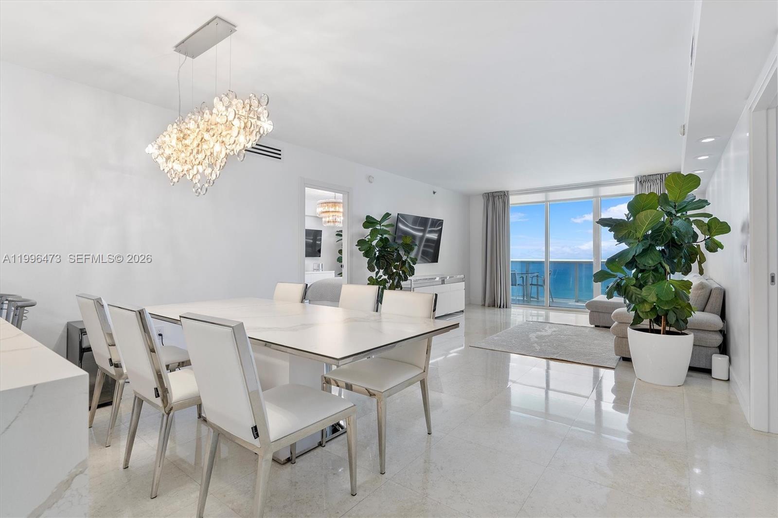 A bright dining and living area features white marble floors, modern furniture, and ocean views — 1830 S Ocean Dr # 4503, Hallandale Beach FL 33009, HALLANDALE BEACH, FL