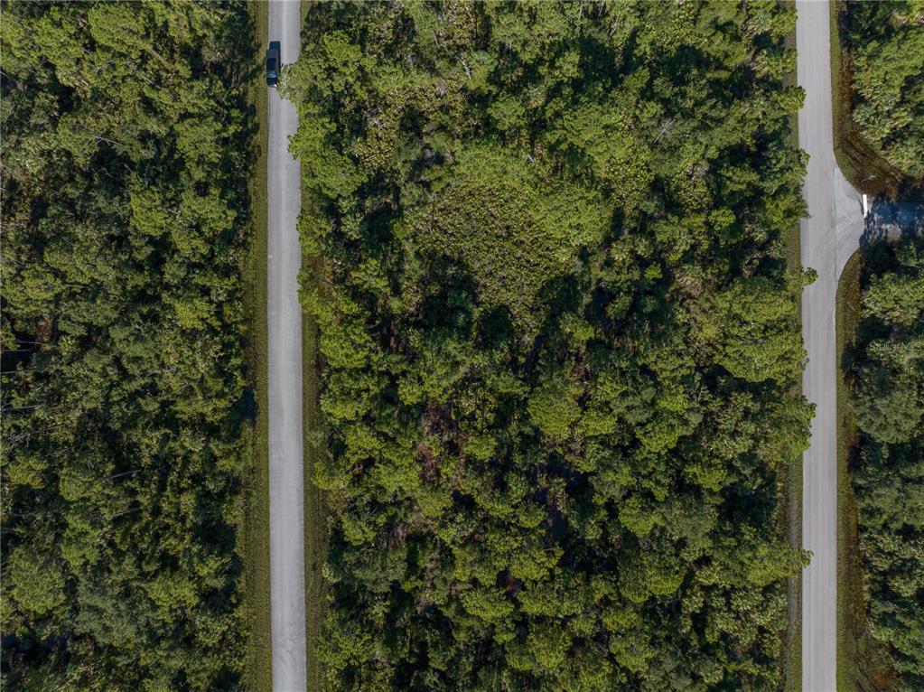 An aerial view shows a wooded lot situated between two paved roads — 14142 DUNLAP AVENUE, PORT CHARLOTTE, FL
