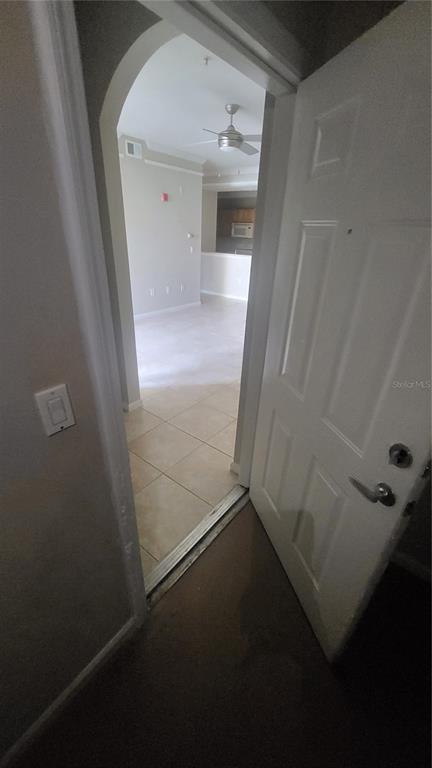 An open white door leads from a carpeted entryway into a tiled room with an archway — 12024 VILLANOVA DRIVE UNIT 103, ORLANDO, FL