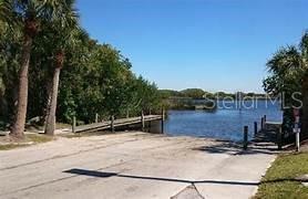 A concrete boat ramp leads to a wooden dock on a calm body of water — 3394 HIGHLANDS ROAD, PUNTA GORDA, FL