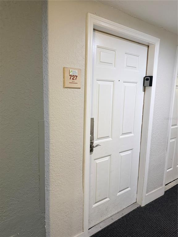 A white six-panel door with a digital lock and a room number sign — 3100 PARKWAY BOULEVARD UNIT 727, KISSIMMEE, FL