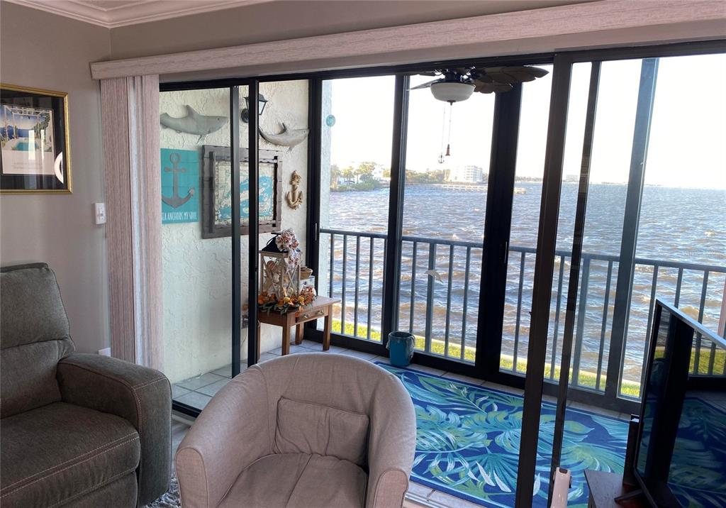 A living room with a balcony overlooking a large body of water — 2465 S WASHINGTON AVENUE UNIT A202, TITUSVILLE, FL