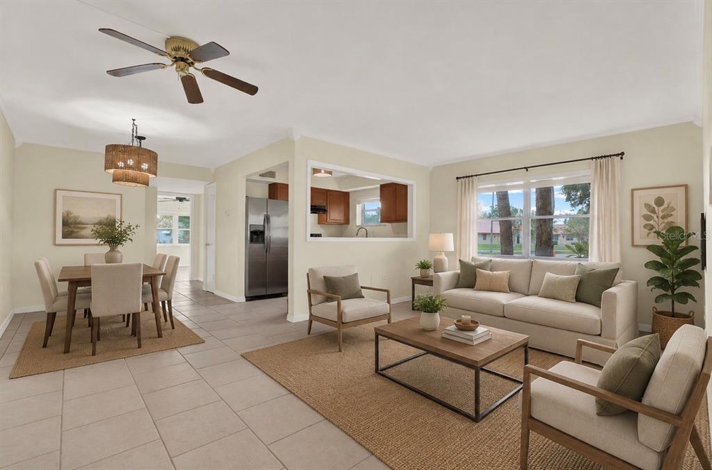 An open-concept living and dining area with tile floors, neutral walls, and a pass-through window — 6360 1ST STREET N UNIT 103, ST PETERSBURG, FL