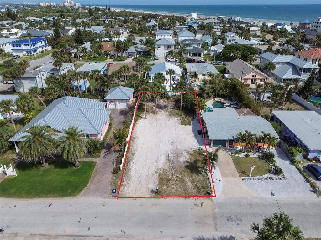 An aerial view shows a vacant, rectangular residential lot outlined in red between two houses — 306 NORMANDY AVENUE, NEW SMYRNA BEACH, FL