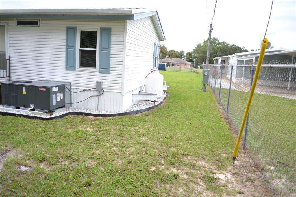 A white manufactured home with blue shutters, a metal staircase, and an outdoor HVAC unit — 5951 SE 158TH COURT, OCKLAWAHA, FL