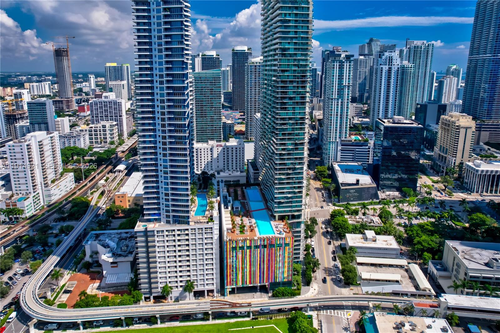 An aerial view of two tall skyscrapers in a dense urban city with a colorful parking garage — 1300 S Miami Ave, Miami FL 33130, MIAMI, FL